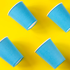 Blue paper glasses on a bright yellow background.