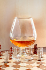 glass with brandy on a chessboard