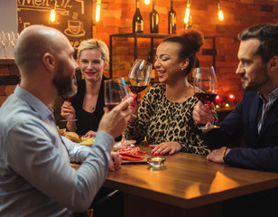 Group of friends having fun talk behind bar counter in a cafe