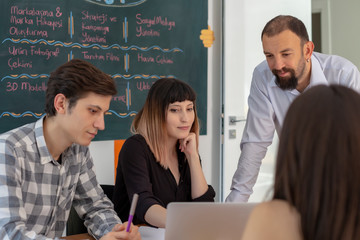 Portrait of cheerful co workers standing in modern creative office with smiling, discussing projects