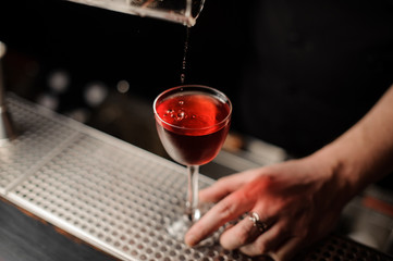 Cherry falls in a drink from special tongs