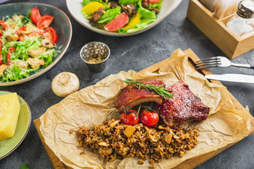 Grilled pork ribs with buckwheat, salads with citrus and grilled liver, Caesar salad with tomato.