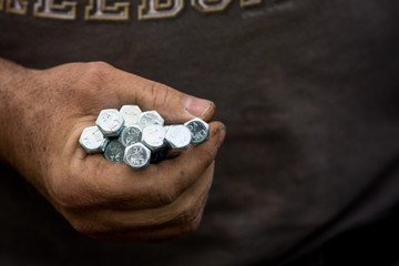 A worker holds bolts to be installed