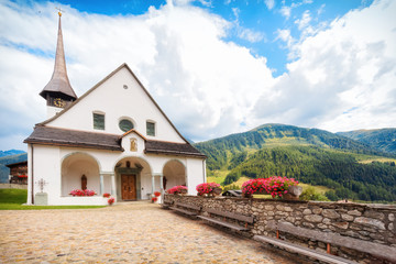 Fototapeta na wymiar Summer classical alpine landscape of Goms village with church Church of St Maria, Switzerland