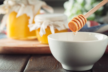 Honey background. Sweet honey in glass jar on wooden background.