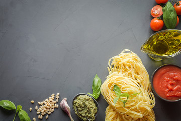 Pasta ingredients for cooking Italian dishes- tagliatelle, tomatoes, basil, olive oil and garlic. Food pattern. Top view with space for text. Horizontal layout. - obrazy, fototapety, plakaty