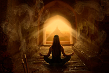 Woman meditating in buddhist temple