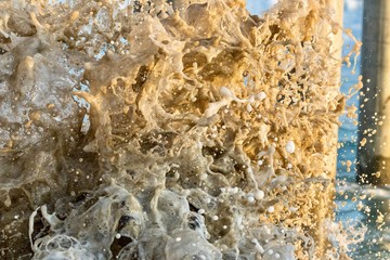 close up of ocean water splashing on sand 
