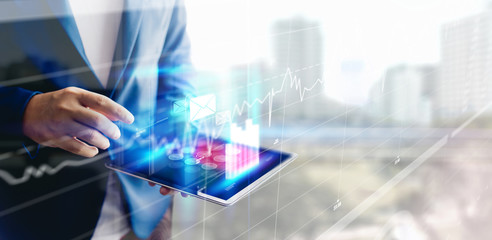 Reflection Businessman using tablet analyzing data and economic growth graph chart and copy space. Concept on tablet with hologram.