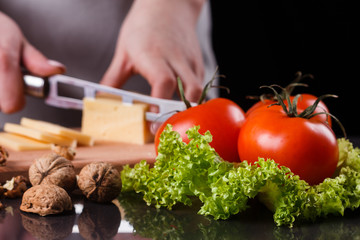 young woman slicing cheese in a gray apron