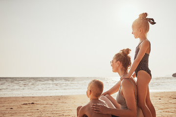 Loving family sitting on a beach looking at the ocean
