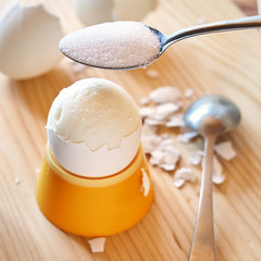 Putting a salt on the boiled chicken egg during breakfast