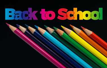 Back to school. Color pencils isolated on black. Text
