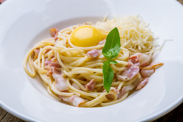 Spaghetti Carbonara with bacon on wooden background