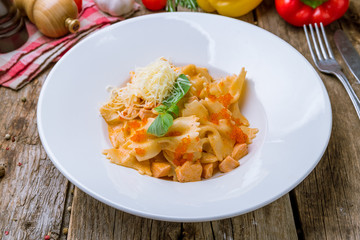 Farfalle with salmon on wooden background
