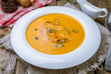 Soup cream of pumpkin on wooden background