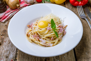 Spaghetti Carbonara with bacon on wooden background
