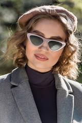 Outdoor shot of a young stylish attractive curly-haired caucasian girl