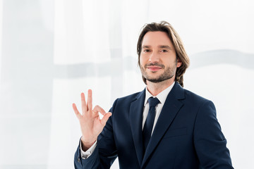 cheerful recruiter showing ok sign and looking at camera
