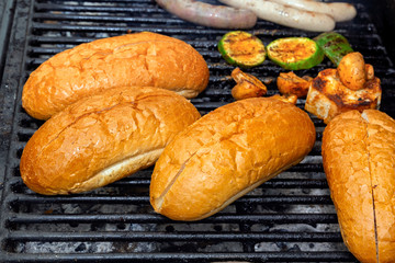 Hot dog buns are heated on a grill on coals. Street food. Close-up