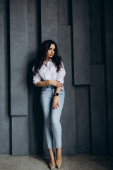 Photo session of a young brunette in jeans and a white shirt.