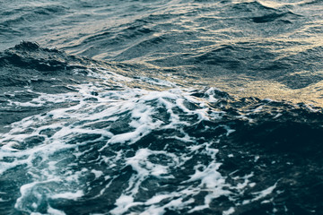 ripples on blue sea water with white foam , natural sea background