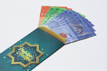 'Duit Raya' is money given from adult to children during Eid al-Fitr celebration in Malaysia. This is a Malay tradition and regarded as alms to the children.