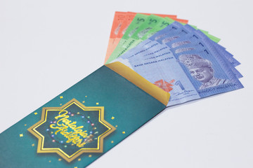 'Duit Raya' is money given from adult to children during Eid al-Fitr celebration in Malaysia. This is a Malay tradition and regarded as alms to the children.
