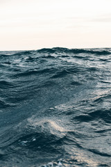 ripples on blue sea water with white foam , natural sea background