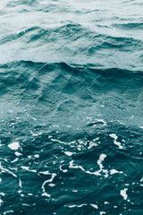 ripples on blue sea water with white foam , natural sea background