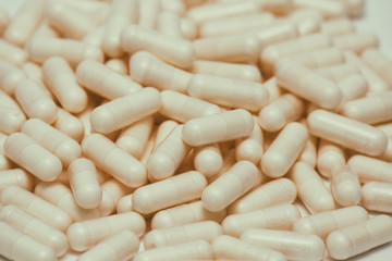 Fototapeta na wymiar Set of many pills. Yellow capsules on white background. Health care pattern concept.