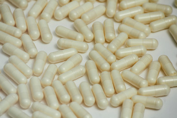 Fototapeta na wymiar Set of many pills. Yellow capsules on white background. Health care pattern concept.