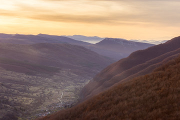 Perfect autumn sunrise above the valley of Dojkinci village and distant horizon mountains