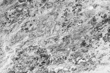 Vintage monochrome background. Rough painted wall of black and white color. Imperfect plane of grayscale. Uneven old decorative backdrop. Texture of black-white. Monochromatic ornamental stony surface