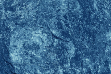 Vintage blue background. Rough painted wall of sapphire color. Imperfect plane of blue colored. Uneven old decorative toned backdrop of cyan tint. Texture of sapphirine hue. Ornamental stony surface.