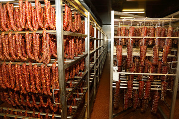 Meat delicacies on the metal frame. The production technology of sausage and smoked meat. Appetizing smoked. Food and groceries. Cooking delicious food. Salami. Sausage Factory. Rows of sausages