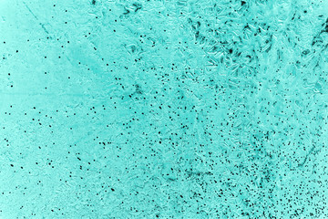Vintage azure background. Rough painted wall of turquoise color. Imperfect plane of cyan colored. Uneven old decorative toned backdrop of aqzure tint. Texture of teal hue. Ornamental stony surface.