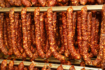 Meat delicacies on the metal frame. The production technology of sausage and smoked meat....
