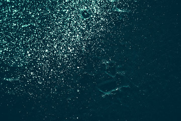 Vintage azure background. Rough painted wall of turquoise color. Imperfect plane of cyan colored. Uneven old decorative toned backdrop of aqzure tint. Texture of teal hue. Ornamental stony surface.