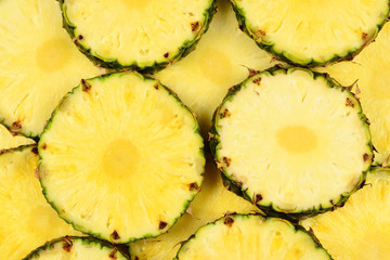 Pineapple juicy yellow slices background. Top view.