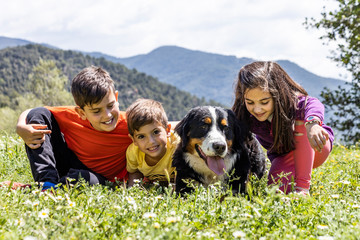 Three little kids with a Bernese dog