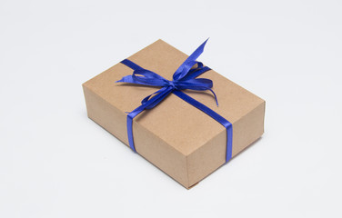Kraft gift box with blue ribbon is on a white background