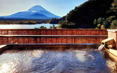The Exotic beautiful peaceful scene of Onsen, japanese hot tub in the morning. background is Fuji Mountain, the famous landmark of Japan, at Shojiko lake, see many bubbles from very hot water in tub. 
