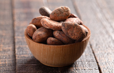 Obraz premium Bowl of Cocoa Beans on a Dark Wooden Table