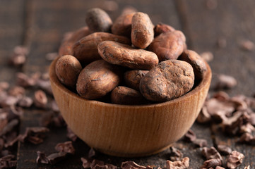 Bowl of Cocoa Beans and Chocolate Nibs on a Dark Wooden Table