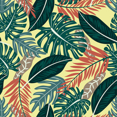Seamless pattern with colorful tropical plants on yellow background. Vector design. Flat jungle print. Floral background.