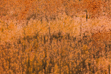 Rusty yellow-red textured metal surface. The texture of the metal sheet is prone to oxidation and corrosion. Textured background in grunge Style