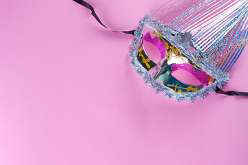 Holographic glittering carnival mask on pink background.Beautiful elegant venetian mask.