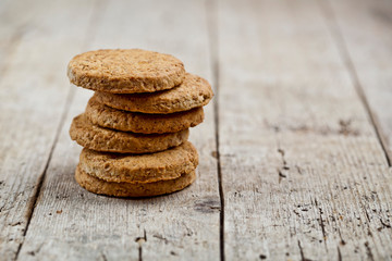 Fototapeta na wymiar Stack of fresh baked oat cookies on rustic wooden table background.