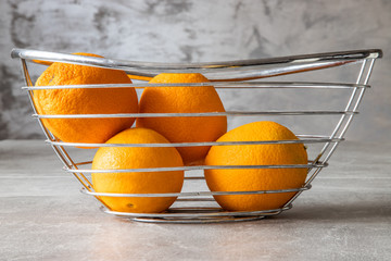Pomarańcze w koszyczku na betonowym tle © andsko